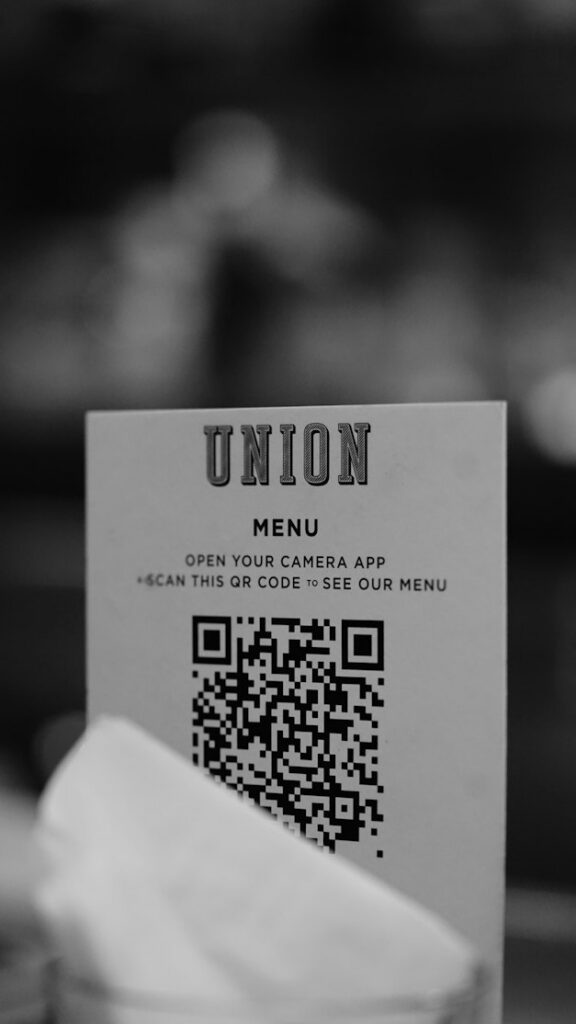 Табличка с QR-кодом меню, частично закрытая предметом на столе