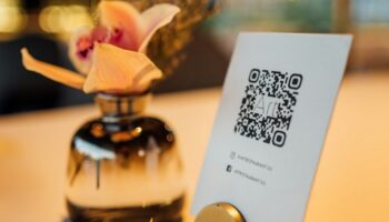 Табличка с QR-кодом на столе рядом с вазой